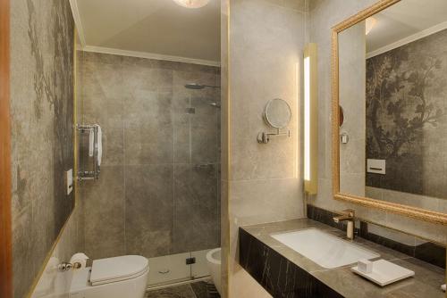 a bathroom with a toilet and a sink and a mirror at NH Venezia Santa Lucia in Venice