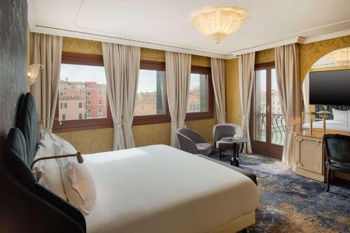 a hotel room with a bed and a large window at NH Venezia Santa Lucia in Venice