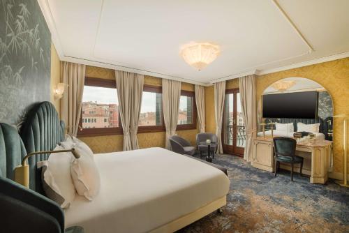 a hotel room with a bed and a desk at NH Venezia Santa Lucia in Venice