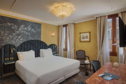 a hotel room with a bed and a table at NH Venezia Santa Lucia in Venice
