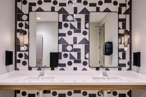 a bathroom with two sinks and two mirrors at Home2 Suites By Hilton Smithfield Selma in Smithfield