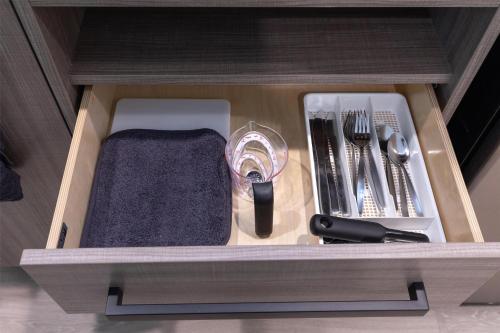 a wooden drawer with utensils in a cabinet at Home2 Suites By Hilton Smithfield Selma in Smithfield