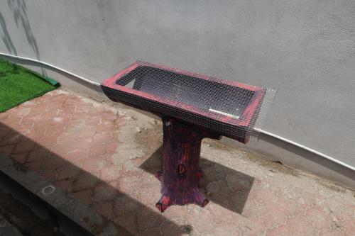 a red bench sitting on a sidewalk next to a building at D'BALI HOMESTAY - Private Swimming Pool, NETFLIX, Internet Wifi ,Cuckoo, Internet Wifi , Dryer, Washing Machine, Aircond Setiap Bilik & Ruang Tamu in Pasir Puteh