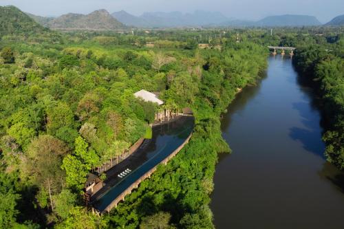 an aerial view of a river with trees and a bridge at Sanctuary Kanchanaburi in Ban Ai Hit