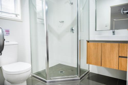 a bathroom with a shower and a toilet and a sink at Standard Queen Room in Gregory Hills - Quaint Spot - Shared Bathroom in Gledswood Hills
