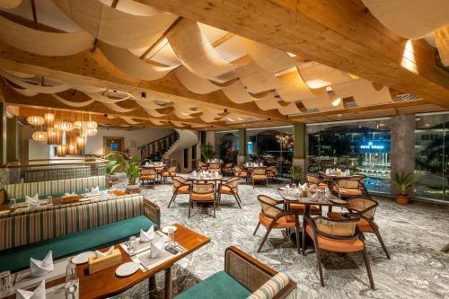a restaurant with wooden ceilings and tables and chairs at White Wharf Beach Resort Morjim Goa in Morjim
