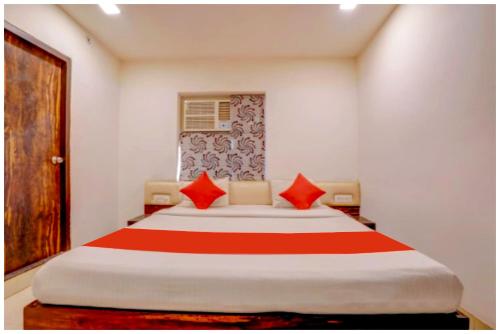 a bedroom with a large bed with red pillows at HOTEL TRAVELLER # INN Near Smrati Park - A Premium Hotel in Lucknow in Lucknow