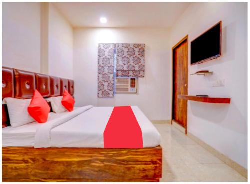 a bedroom with a large bed with red pillows at HOTEL TRAVELLER # INN Near Smrati Park - A Premium Hotel in Lucknow in Lucknow