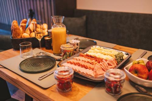 a table with a tray of food and a tray of fruit at Das Goldjuwel - Luxury Apartments with private Spa in Goldegg