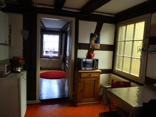 - une cuisine avec un four micro-ondes au-dessus d'une armoire en bois dans l'établissement Gîte Au Fil Du Temps, à Colmar