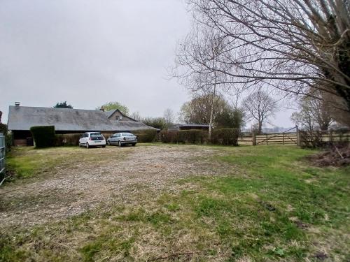 two cars parked in a field next to a barn at La Baie d'Authie by les Jumelles de la Baie in Villers-sur-Authie