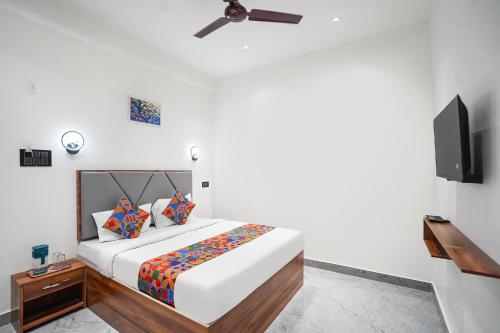 a bedroom with a bed and a flat screen tv at FabHotel The Shivaay Palace in Varanasi