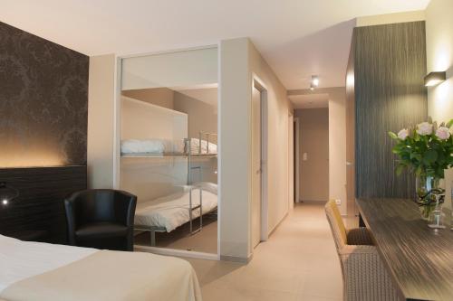 a hotel room with a bed and a desk and a bedroom at Hotel Princess in Ostend