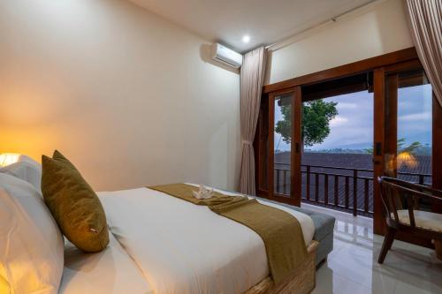 a bedroom with a bed and a balcony with a view at Angseri Villas in Tabanan