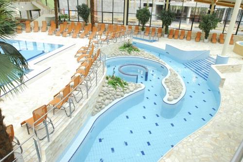 a swimming pool with a slide in a building at Hotel Tulipan Pruhonice in Prŭhonice