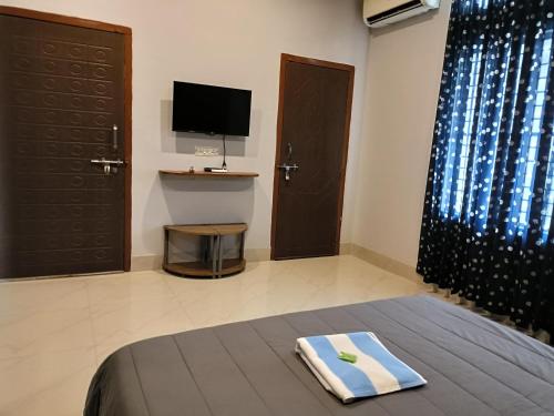 a bedroom with a bed and a tv and a bed sidx sidx sidx at Areca Homestay in Guwahati