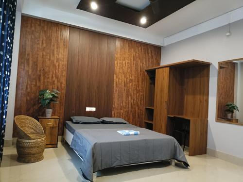 a bedroom with a bed and a wooden wall at Areca Homestay in Guwahati