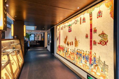a hallway with a wall with paintings on it at Beijing Shichahai Shadow Art Performance Courtyard in Beijing