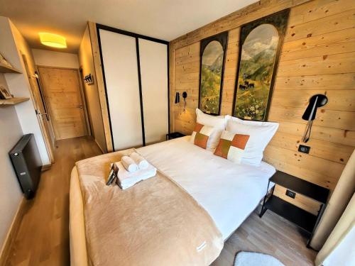 une chambre avec un grand lit dans une pièce dans l'établissement Chalet 1839 - Emplacement idéal entre centre et pistes MAE-2413, aux Gets