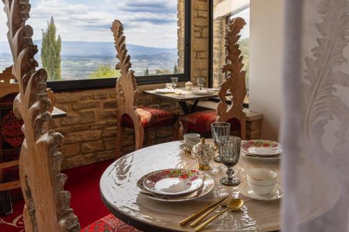 a table and chairs in a room with a window at Le Palais d'Aglaé, Hôtel de Charme in Gordes