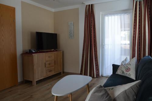 a living room with a couch and a tv at Haus Regenbogen in Pertisau