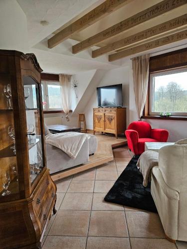 a bedroom with a bed and a couch and a tv at Gästehaus Senger in Bestwig