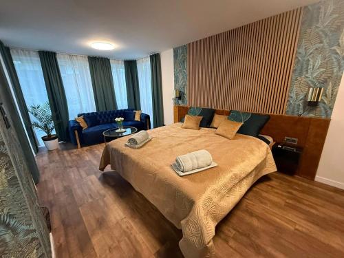 a bedroom with a bed with two towels on it at MONTANA Wellness Apartman in Biatorbágy