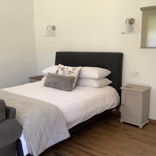 a bedroom with a bed with white sheets and pillows at Chambres d'Hôtes Belle Vallee in Domfront