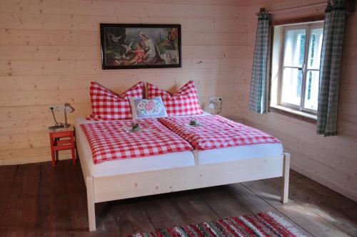 a bed with red and white pillows in a room at Ferienhaus Eckstoa in Abtenau