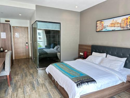 a bedroom with a large bed and a tv on the wall at KEP BAY HOTEL & RESORT in Kep