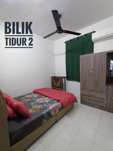 a bedroom with a bed and a dresser at Dsyaf Idaman Homestay in Jasin