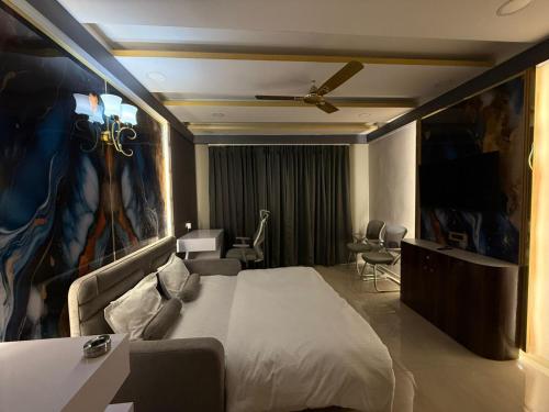 a hotel room with a bed and a painting on the wall at Studio z leisure stay in Lucknow