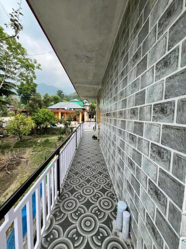 ビーアにあるBir Breeze Homestaysのレンガの壁とタイルフロアのバルコニー