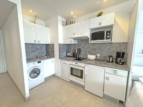 une cuisine avec des armoires blanches et une laveuse et une sécheuse dans l'établissement PROMENADE HOLIDAY - ROYAL LUXEMBOURG PROMENADE, à Nice