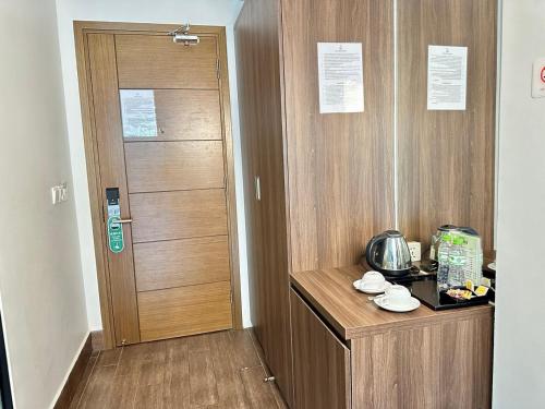 a room with a door and a table with a kitchen at KEP BAY HOTEL & RESORT in Kep