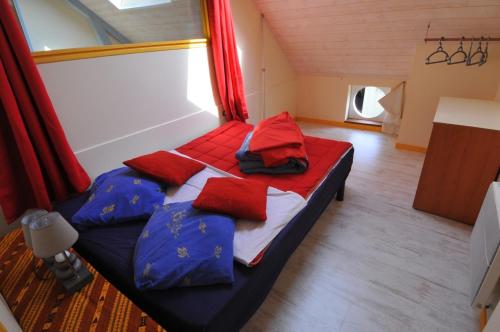Ce lit se trouve dans un dortoir doté d'oreillers rouges et bleus. dans l'établissement gîte ERZIWEZH, à Sainte-Marie