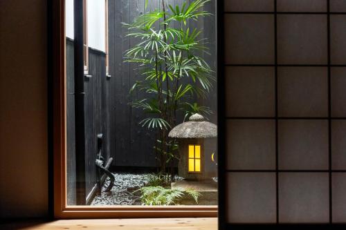 a window with a view of a garden with a light at YADORU KYOTO HANARE Shirotaki No Yado in Kyoto