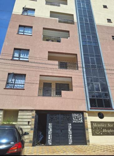 a building with a car parked in front of it at Koki Airbnbs Kamakis in Ruiru