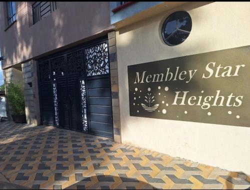 a sign on the side of a building with a door at Koki Airbnbs Kamakis in Ruiru
