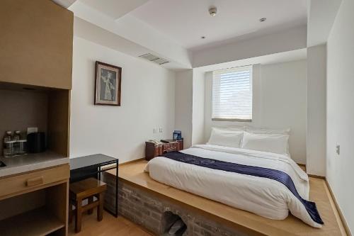 a bedroom with a large bed and a window at Beijing Shichahai Shadow Art Performance Courtyard in Beijing