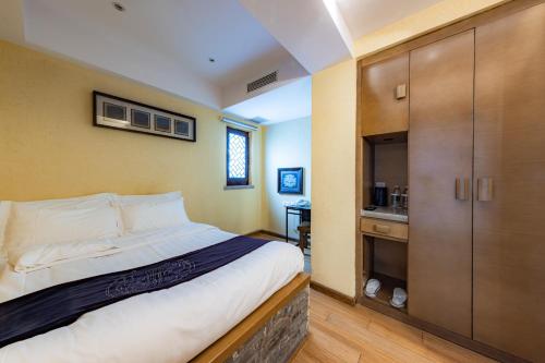 a bedroom with a large bed and a bathroom at Beijing Shichahai Shadow Art Performance Courtyard in Beijing