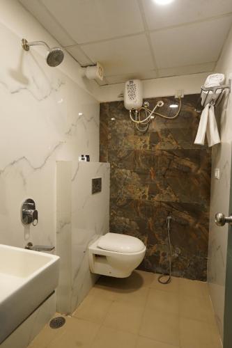 a bathroom with a toilet and a sink and a shower at The Byke Business - Landmark Pan India Pure Veg Hotel Chain in Indore