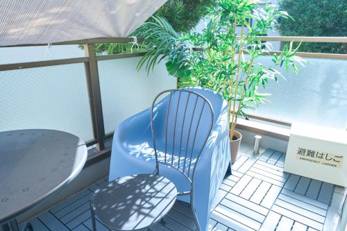 a blue chair sitting on a balcony with plants at FINOA Residential Suite Kamata in Tokyo