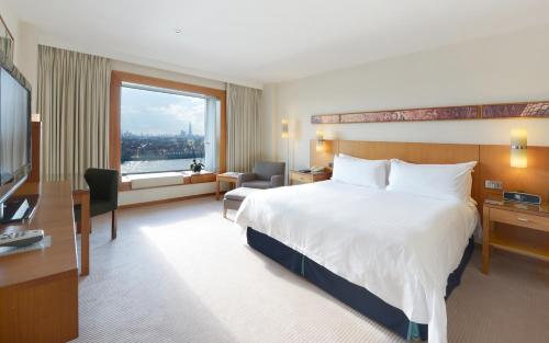 a hotel room with a large bed and a window at Canary Riverside Plaza Hotel in London