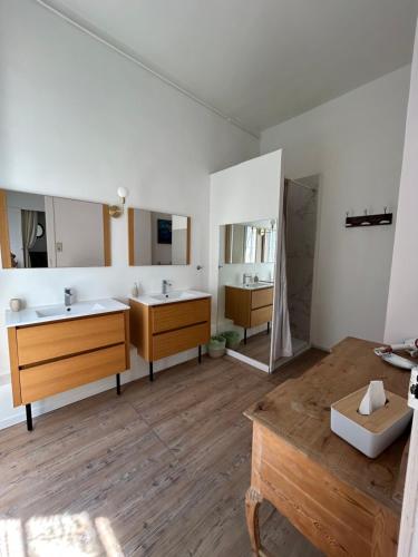 a bathroom with two sinks and two mirrors at L Oranger in Rivesaltes