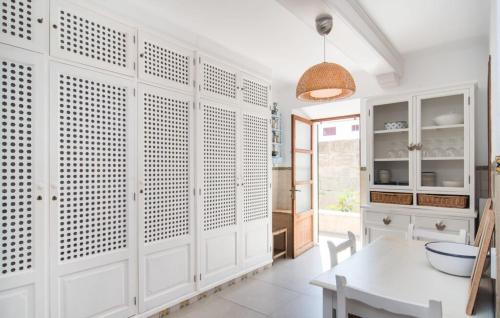 a kitchen with white cabinets and a table at Villa Cabrera in Colonia Sant Jordi
