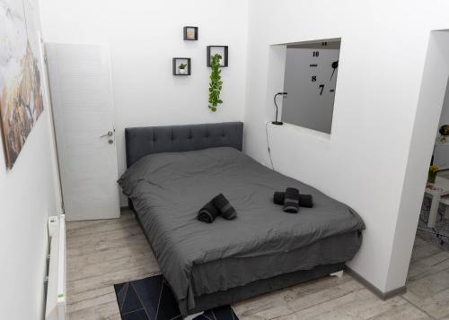 a small bedroom with a bed with shoes on it at El Mundo Apartman in Bečej