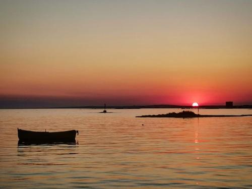 a boat sitting in the water at sunset at Nina casa vacanze in Leverano