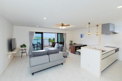 宮古島にあるHotel & Villa Seahorse MIYAKOJIMAのリビングルーム(ソファ付)、ダイニングルーム