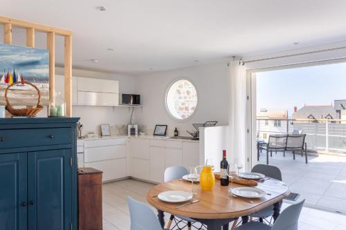 une cuisine et une salle à manger avec une table et des chaises dans l'établissement Bel Horizon - avec terrasse vue mer, à Pléneuf-Val-André